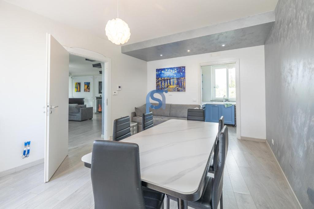 une salle à manger avec une table et des chaises blanches dans l'établissement Villa Azzurra con piscina privata, à Lascari