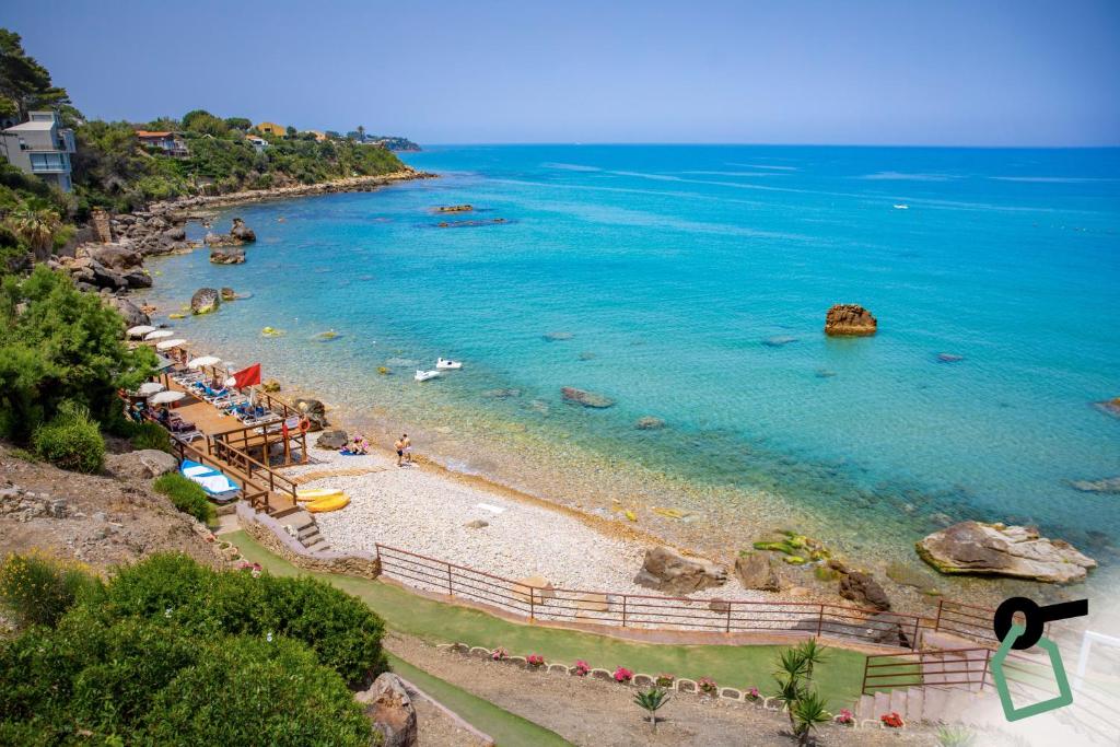- une plage avec un groupe de personnes et l'océan dans l'établissement Hotiday Apartments Cefalù, à Cefalù