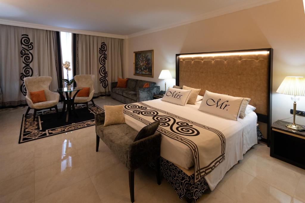 une chambre avec un grand lit et un salon dans l'établissement Hotel Ariston, à Paestum