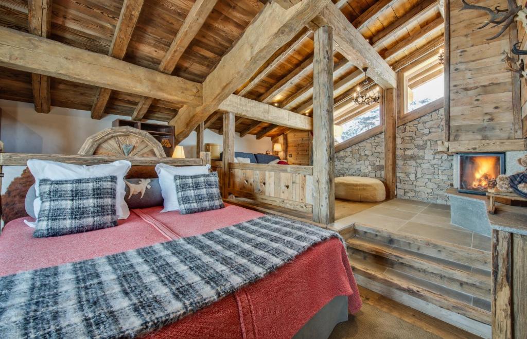 Cette cabane en rondins comprend un lit et une cheminée. dans l'établissement La Bouitte - Hôtel Relais & Châteaux, à Saint-Martin-de-Belleville 37 autres photos