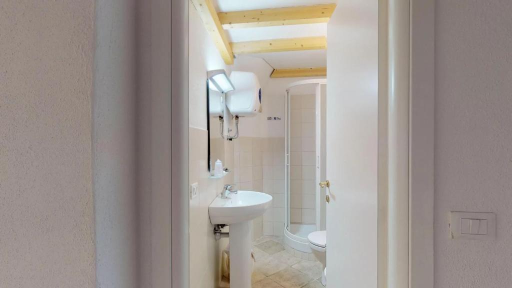 une salle de bain blanche avec un lavabo et des toilettes dans l'établissement Casa del Teatro, à Borgio Verezzi