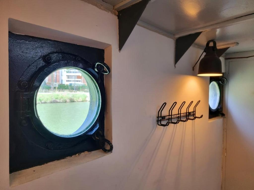 une fenêtre ronde sur un mur avec une fenêtre dans l'établissement Péniche de charme avec jacuzzi sur canal du midi, à Toulouse