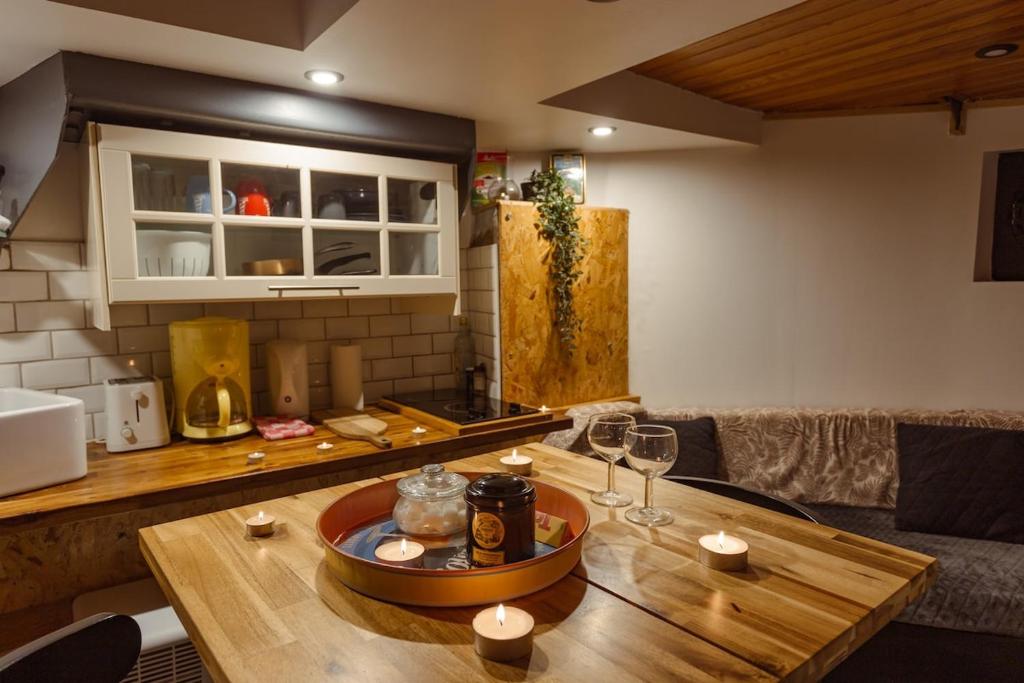 - une cuisine avec une table en bois et des verres à vin dans l'établissement Péniche de charme avec jacuzzi sur canal du midi, à Toulouse