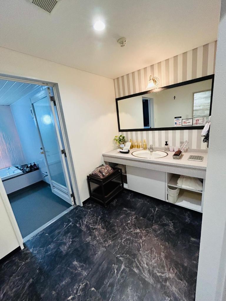 une salle de bain avec un lavabo et un grand miroir dans l'établissement Pal Annex Nakatsu (Love Hotel), à Nakatsu 25 autres photos