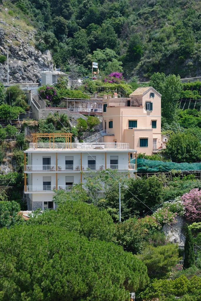 un bâtiment sur le côté d'une colline plantée d'arbres dans l'établissement Residence La Dolce Vita, à Maiori