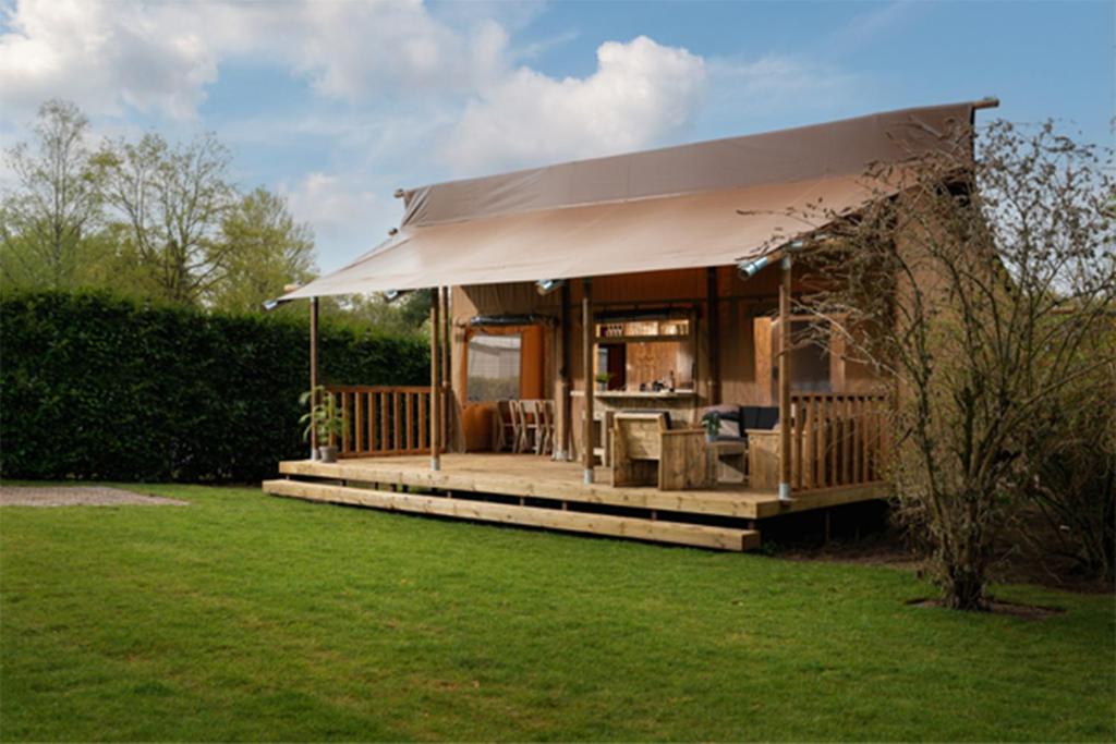 une petite maison avec un auvent dans une cour dans l'établissement Camping Le Val de Cesse, à Mirepeisset