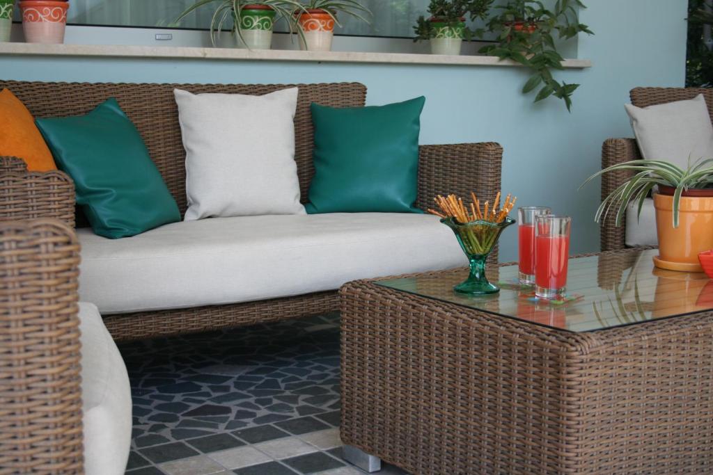 - un canapé en rotin avec des oreillers et une table dans l'établissement Hotel Diamante, à Francavilla al Mare