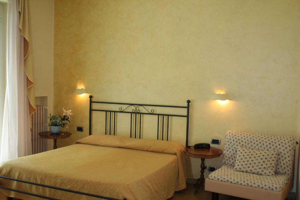 une chambre avec un lit et une chaise dans l'établissement Hotel Diamante, à Francavilla al Mare 115 autres photos