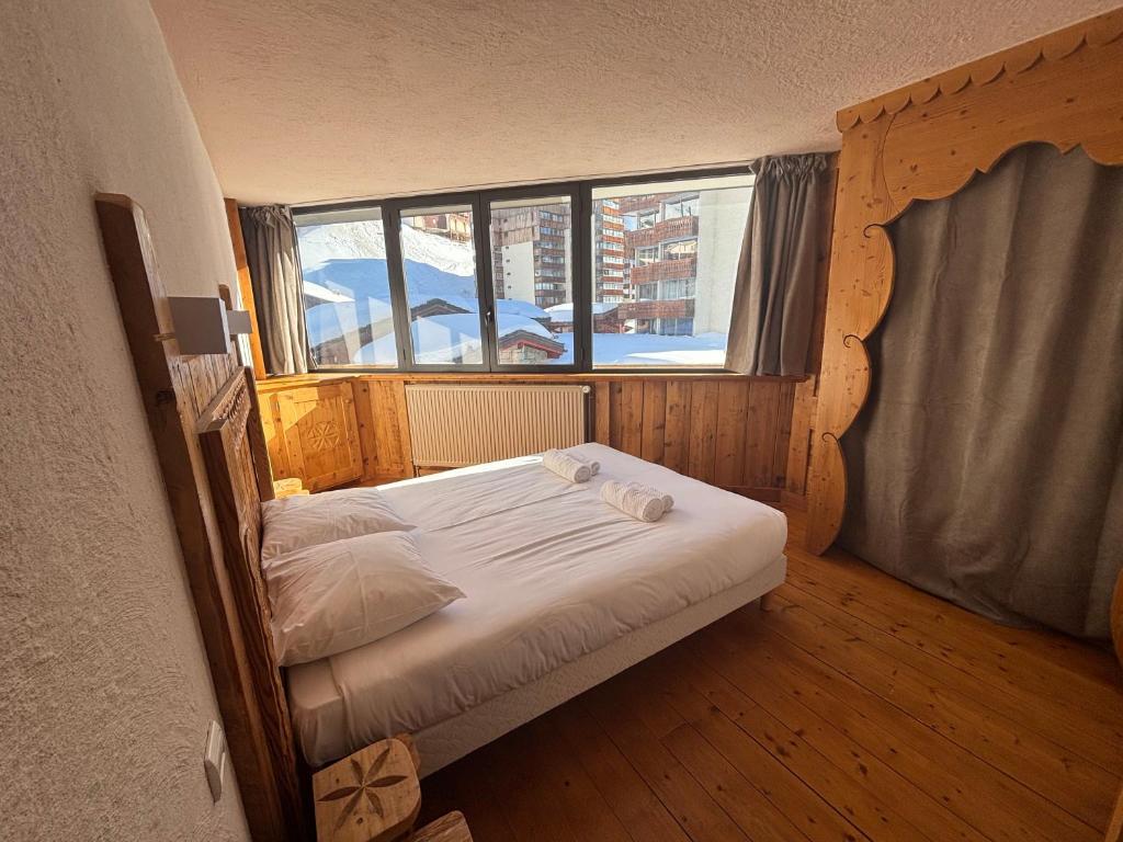 - un petit lit dans une chambre dotée d'une grande fenêtre dans l'établissement Résidence Le Portillo, à Val Thorens