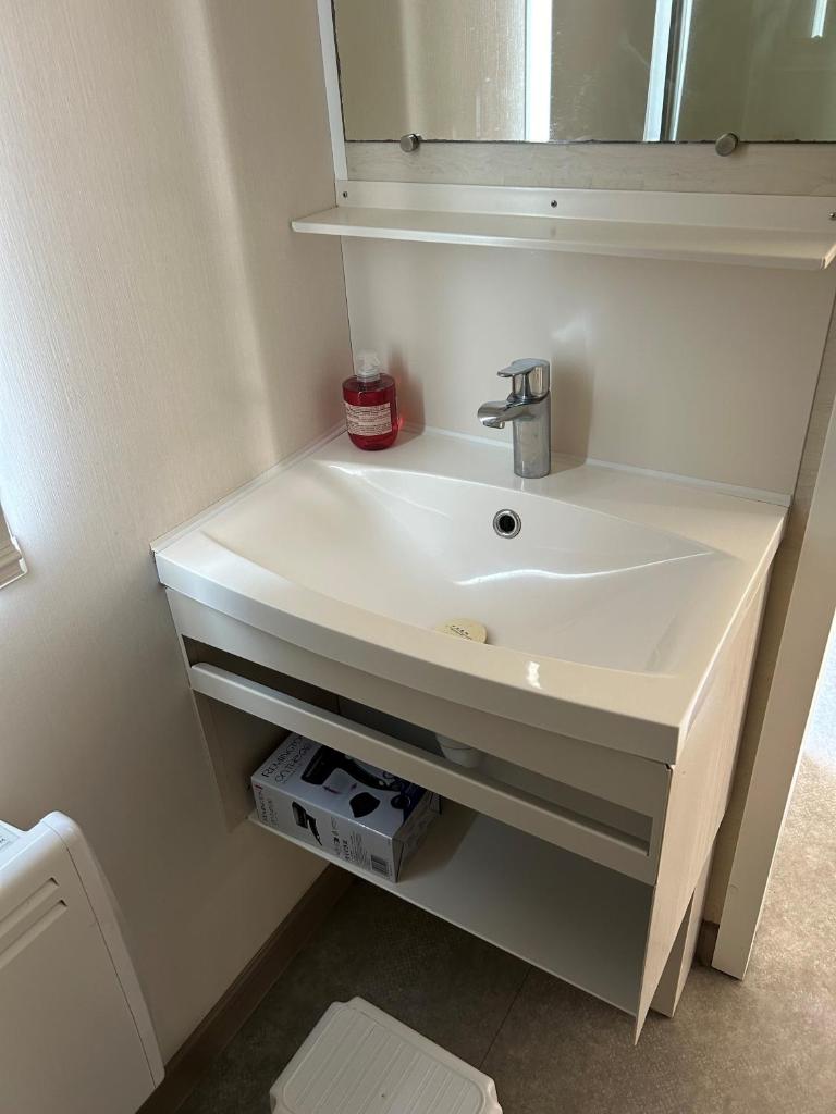 une salle de bain avec un lavabo blanc et un miroir dans l'établissement Mobil-home 3 ch camping TOHAPI, à Port-la-Nouvelle
