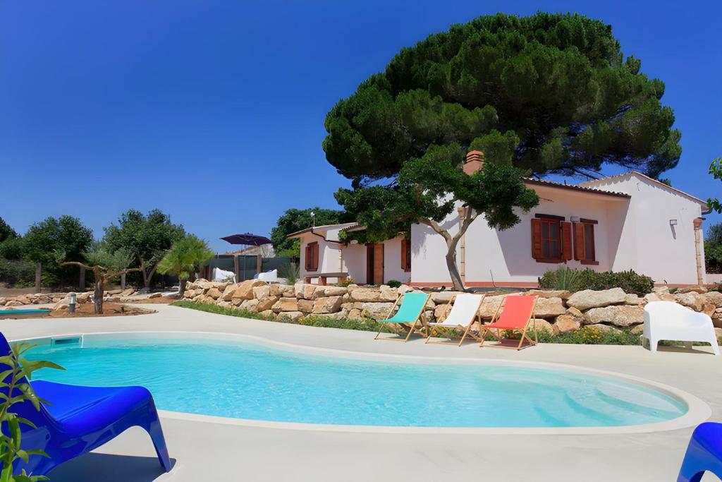 une piscine avec des chaises et une maison dans l'établissement Villa 2 Pini, à Alcamo