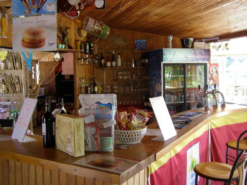 - un restaurant avec un comptoir où vous trouverez de la nourriture et des bouteilles de vin dans l'établissement Camping 4 étoiles - Piscine - ccafgef, à La Haye-du-Puits