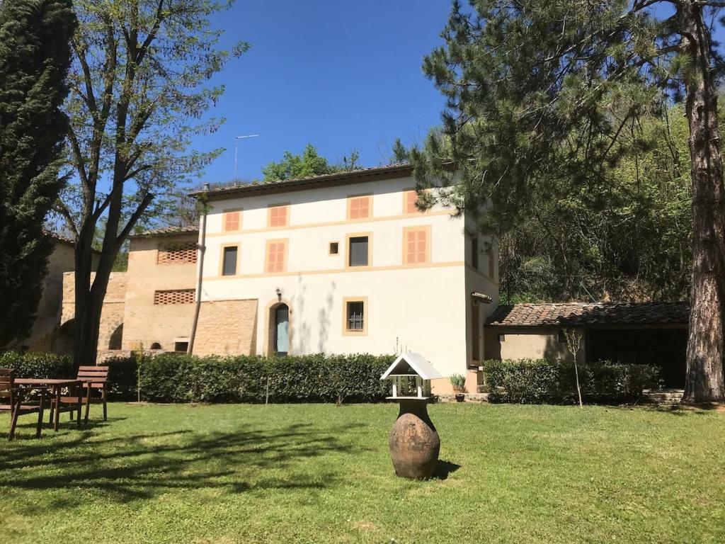 un bâtiment avec un alimentateur d'oiseaux dans l'herbe dans l'établissement Casale Molin Bianco nelle colline del Chianti, à Castellina Scalo
