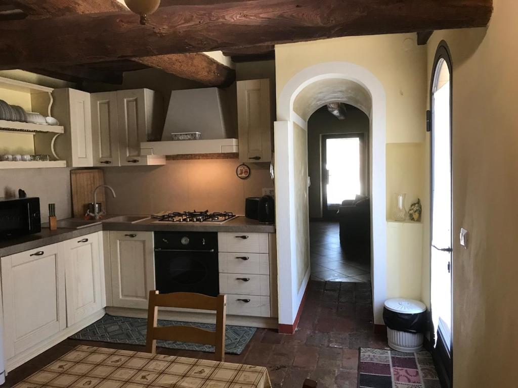 une cuisine avec des armoires blanches et un four à plaques de cuisson dans l'établissement Casale Molin Bianco nelle colline del Chianti, à Castellina Scalo 19 autres photos