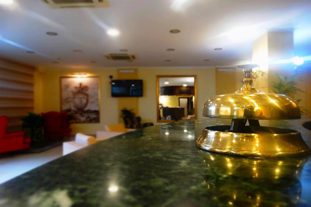 un objet en or au-dessus d'un comptoir dans une pièce dans l'établissement Hotel Orizzonte, à Letojanni