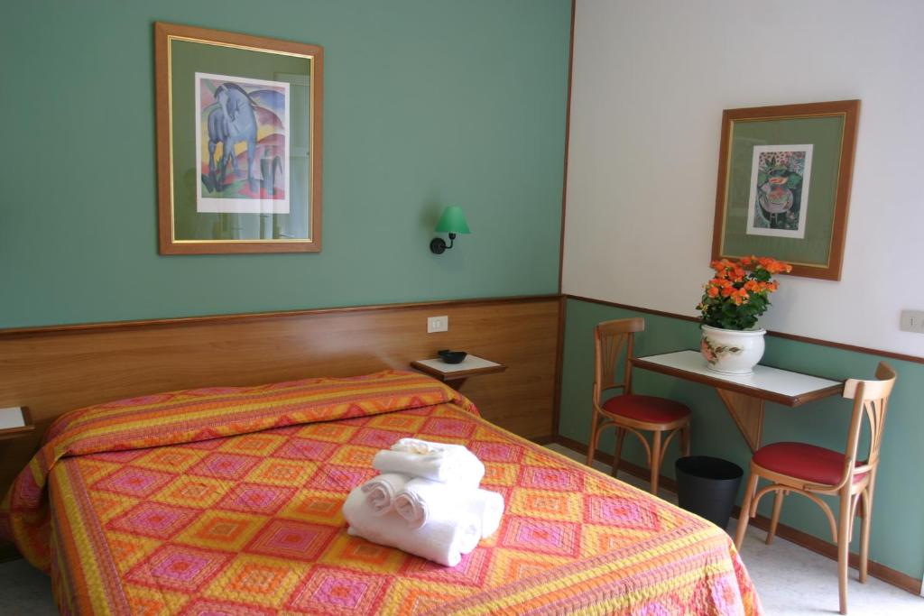 une chambre avec un lit, une table et des chaises dans l'établissement Villa Romana, à Lignano Sabbiadoro