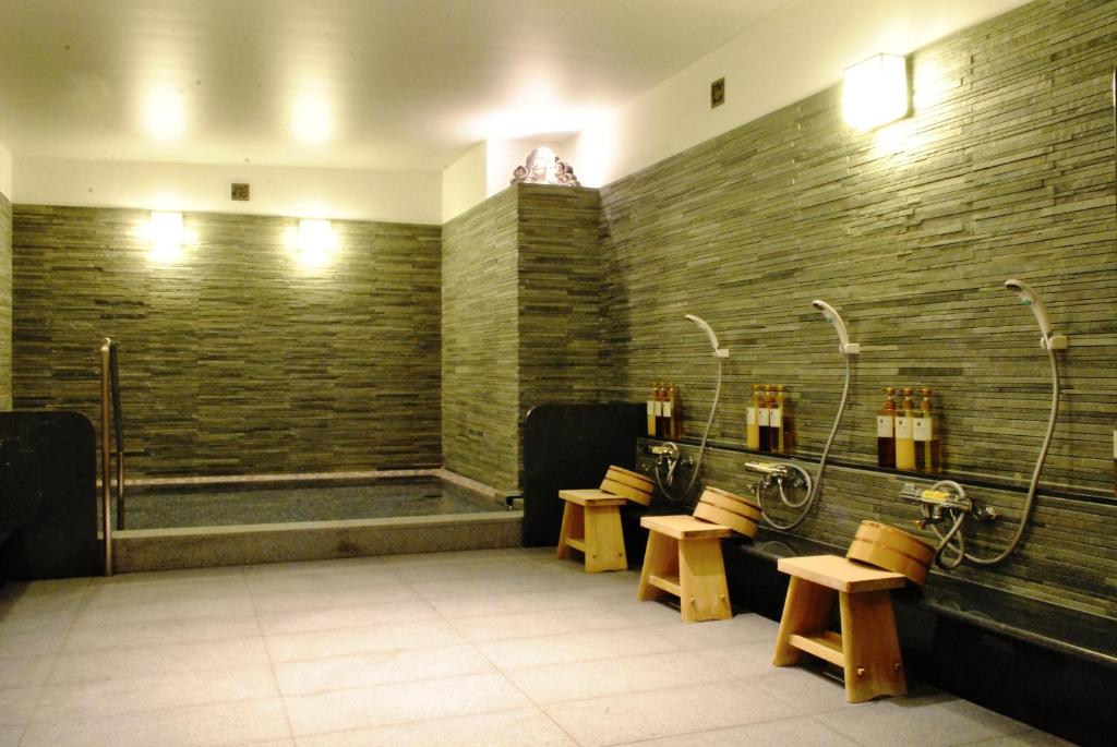 - une salle de bains commune pourvue de bancs et d'une douche dans l'établissement Nissho Besso, à Kyoto