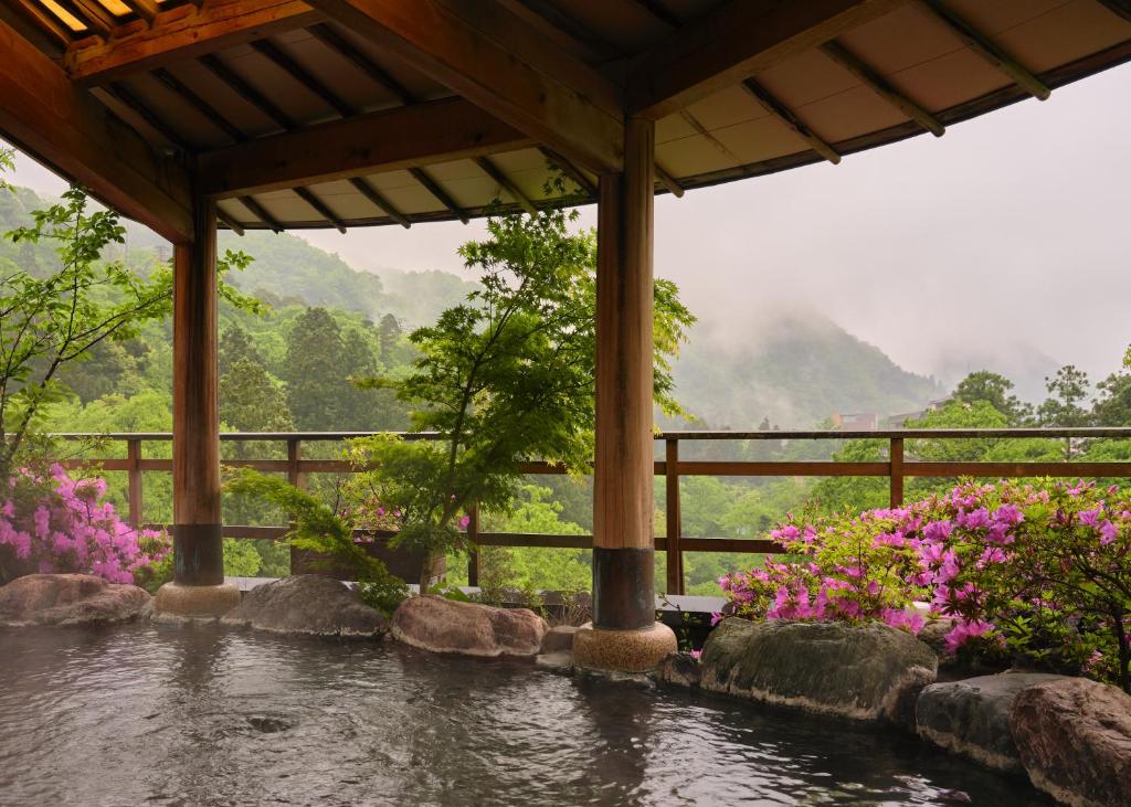 - une vue sur la rivière dans un jardin fleuri dans l'établissement Yamanakaonsen Hanamurasaki, à Kaga