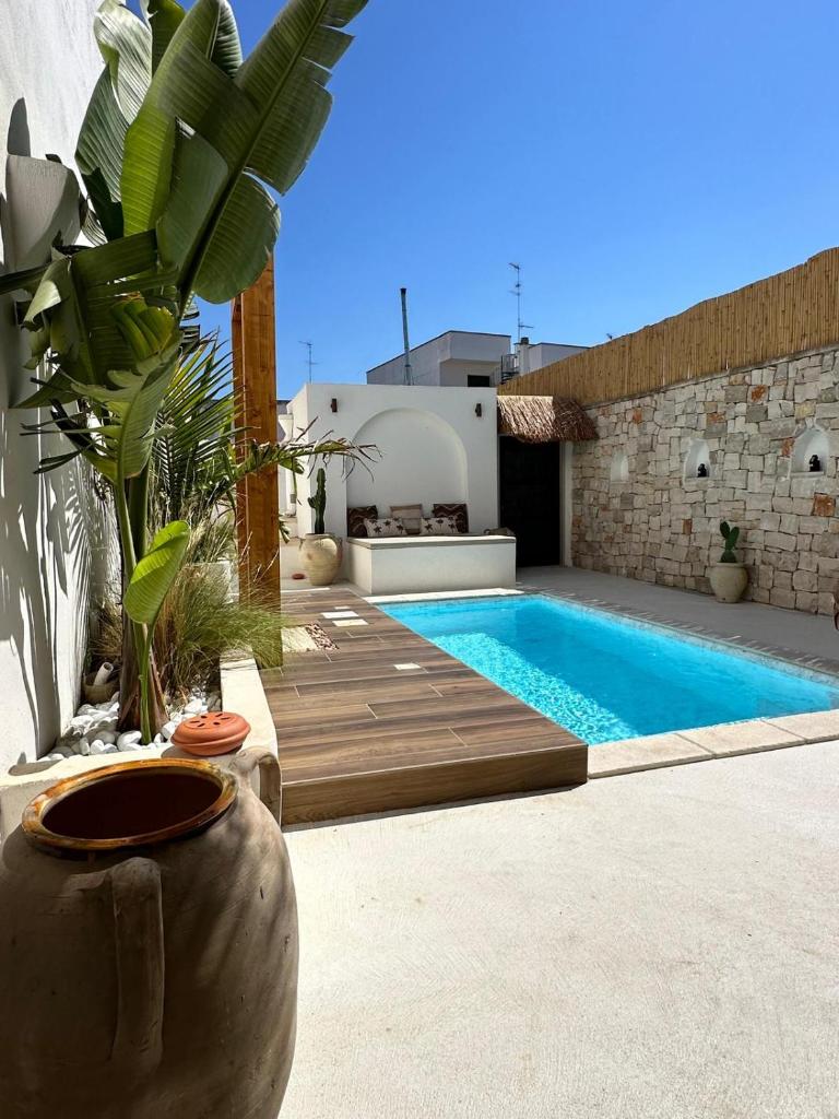 une piscine dans une cour arrière avec une villa dans l'établissement Midi Pool Villa & SPA, à Veglie