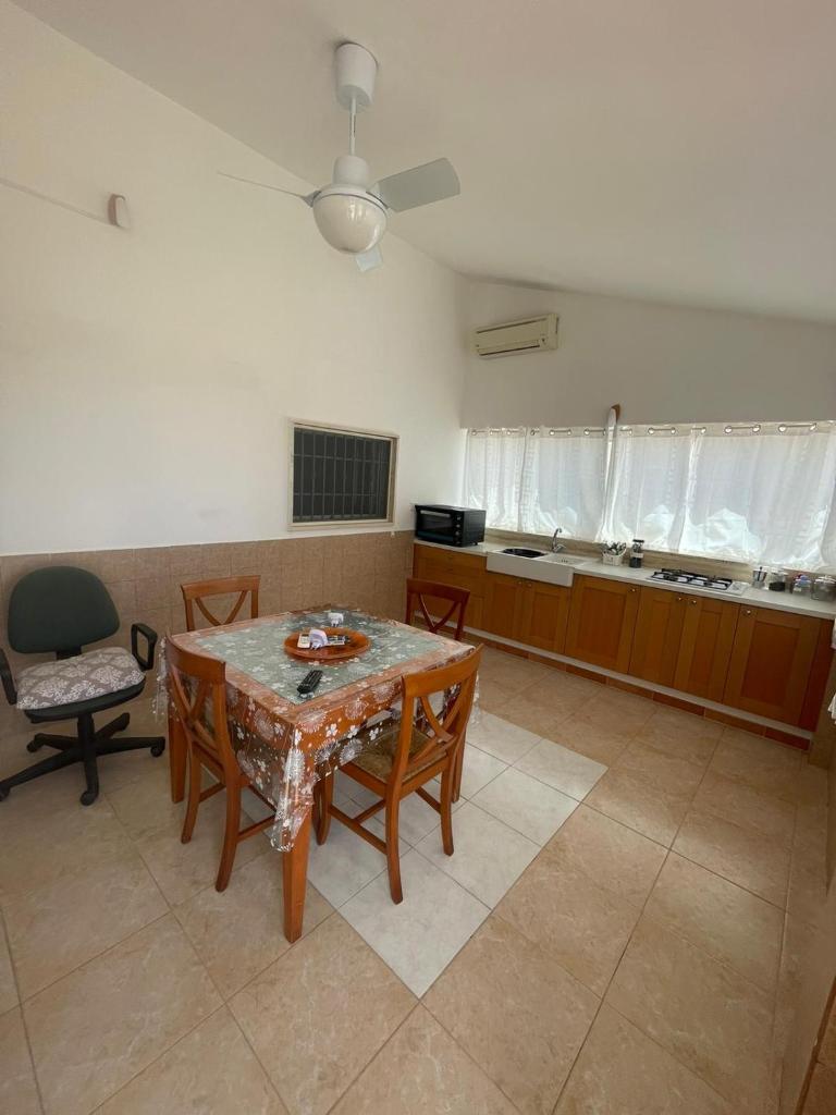 une cuisine avec une table et des chaises dans une pièce dans l'établissement Maracaibo Village, à Tarente