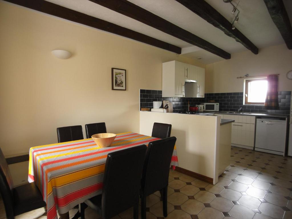 une cuisine et une salle à manger avec une table et des chaises dans l'établissement Gîte Poire - Les Gîtes de la Lohuas, à Les Champs-Géraux