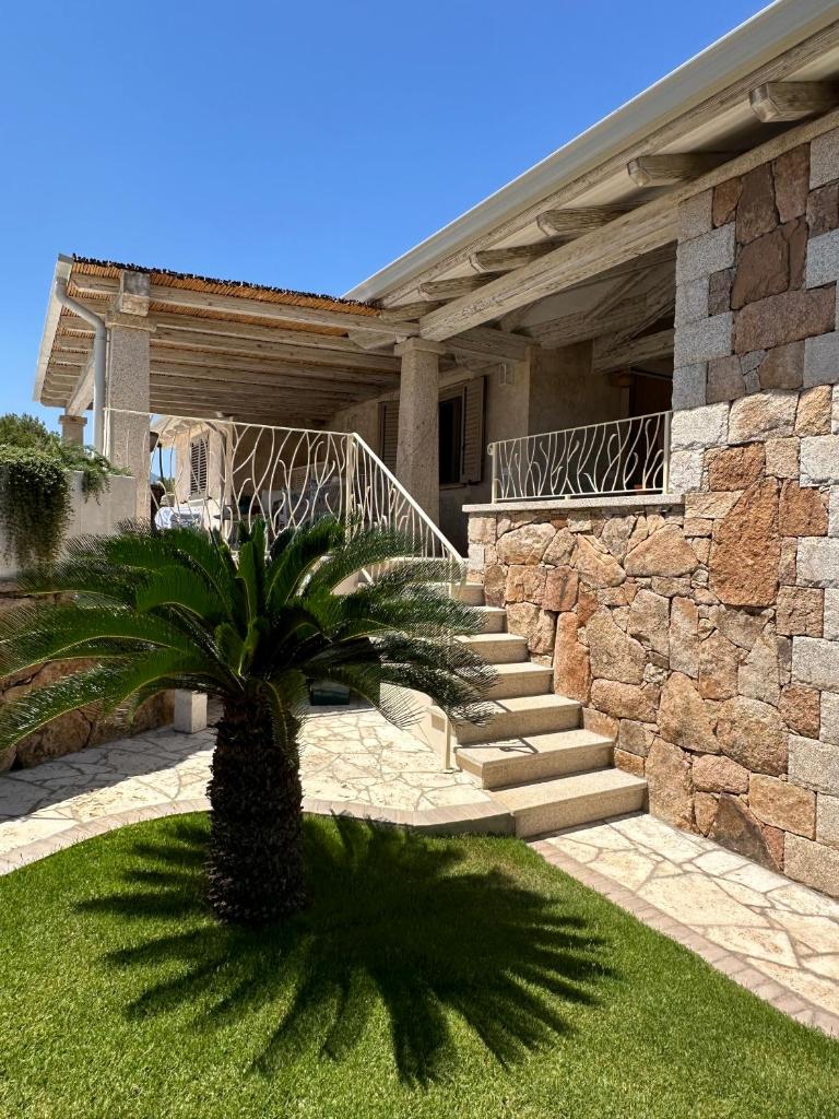 une maison avec un palmier dans la cour avant dans l'établissement Villa Smeraldo Castiadas, à Castiadas 33 autres photos