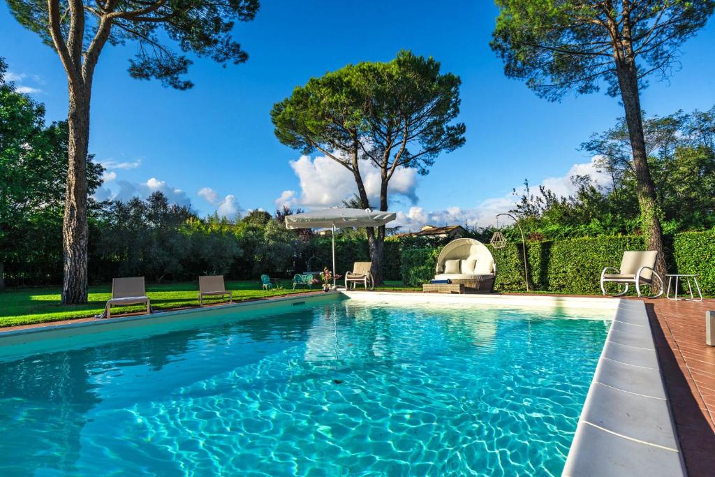 - une piscine dans une cour avec des chaises et des arbres dans l'établissement Villa Ines charme near Lucca, à Altopascio