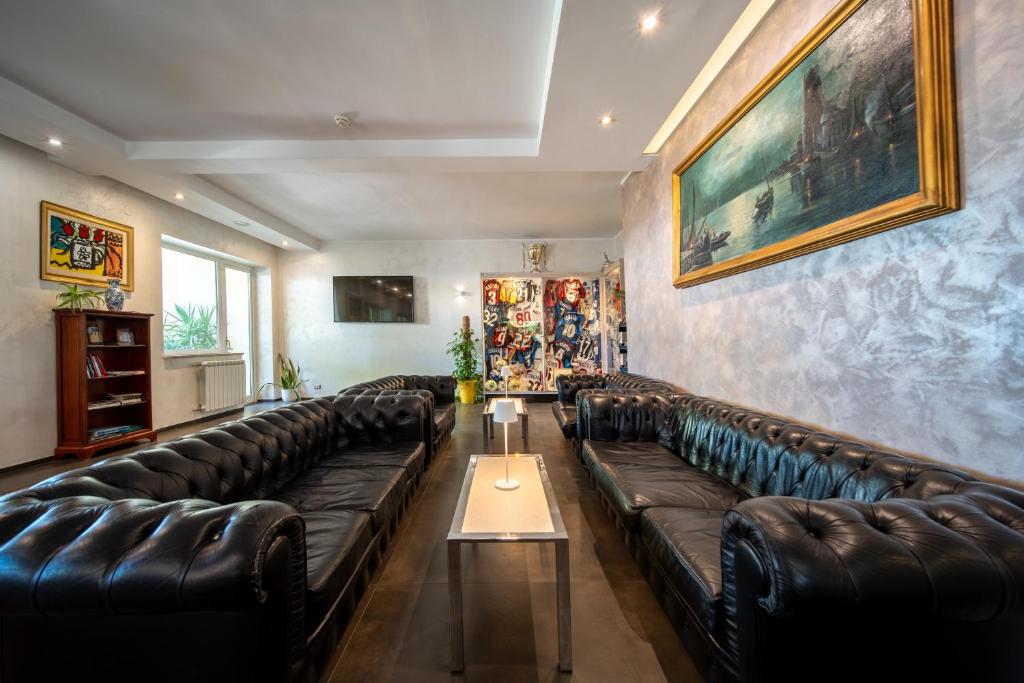 - un salon avec des canapés en cuir et une table dans l'établissement Hotel Villa, à Bisceglie