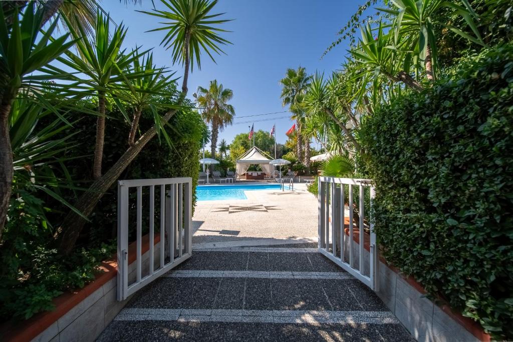 une porte menant à une piscine bordée de palmiers dans l'établissement Hotel Villa, à Bisceglie