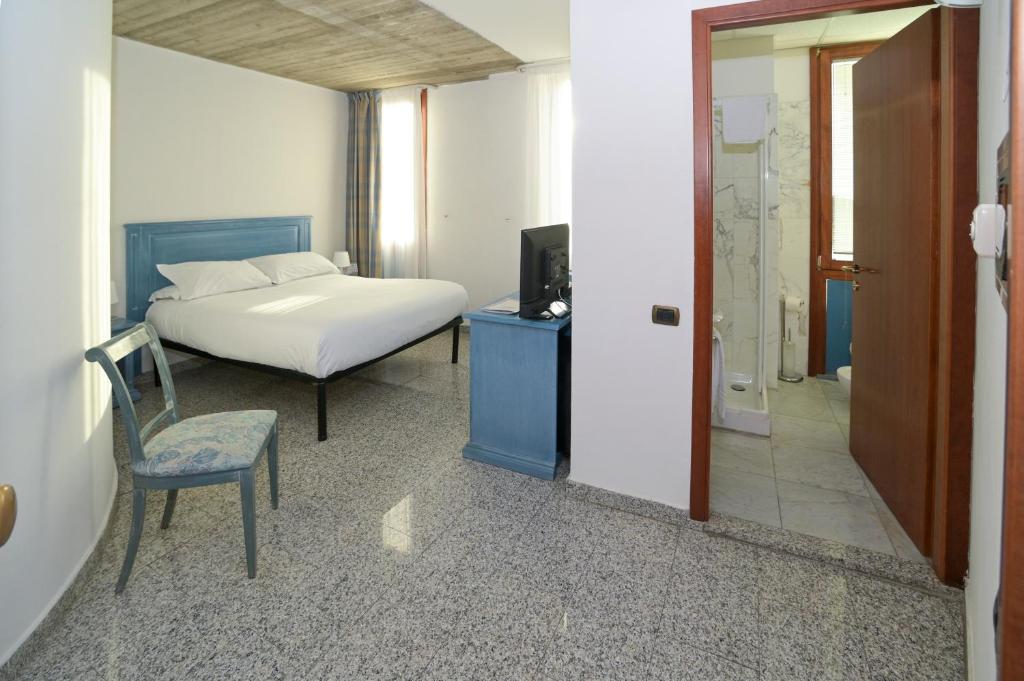 une chambre avec un lit, une chaise et une télévision dans l'établissement Residence Hotel L'incanto Di Boccadarno, à Marina di Pisa