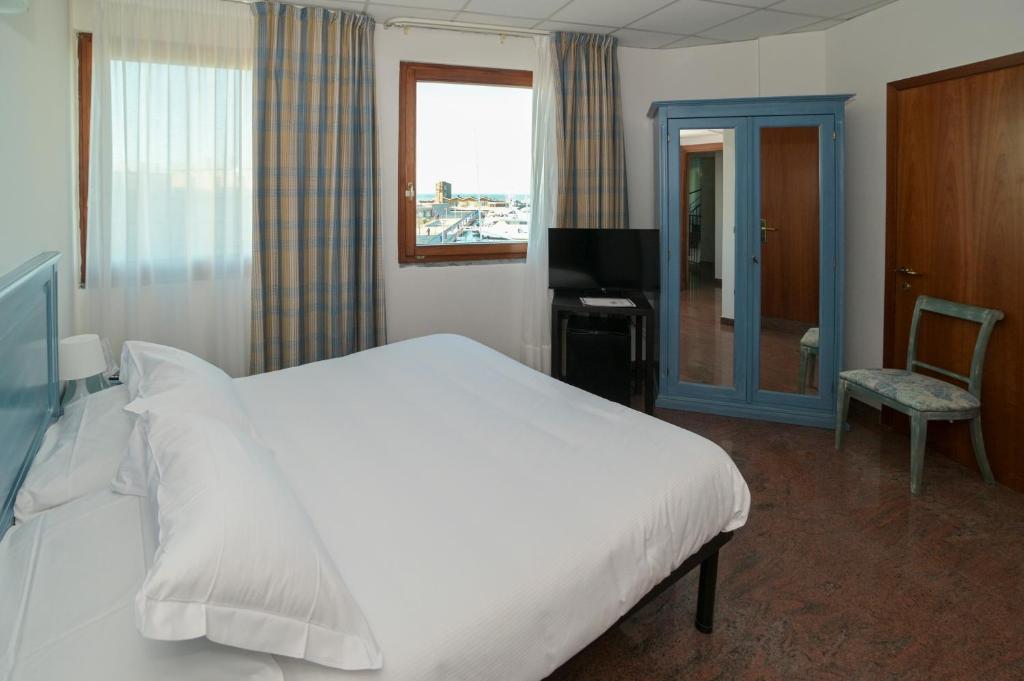 une chambre avec un grand lit blanc et une télévision dans l'établissement Residence Hotel L'incanto Di Boccadarno, à Marina di Pisa 75 autres photos