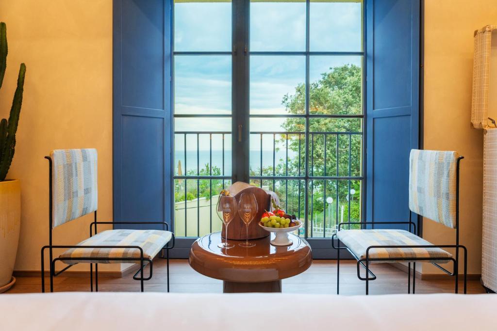 une chambre avec deux chaises, une table et une fenêtre dans l'établissement Hidden Dalla Gioconda, à Gabicce Mare