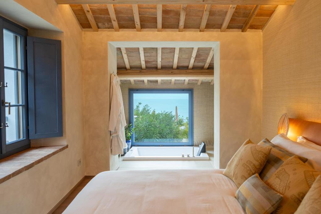 une chambre avec un lit et une grande fenêtre dans l'établissement Hidden Dalla Gioconda, à Gabicce Mare