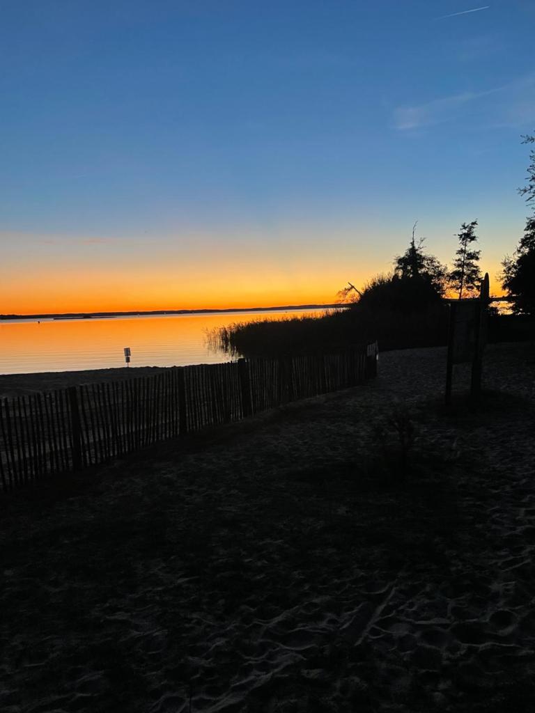 - un coucher de soleil sur la plage avec une clôture dans l'établissement Mobilhome bord du lac, à Parentis-en-Born