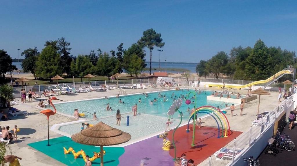 - une grande piscine avec des personnes dans un parc aquatique dans l'établissement Mobilhome bord du lac, à Parentis-en-Born