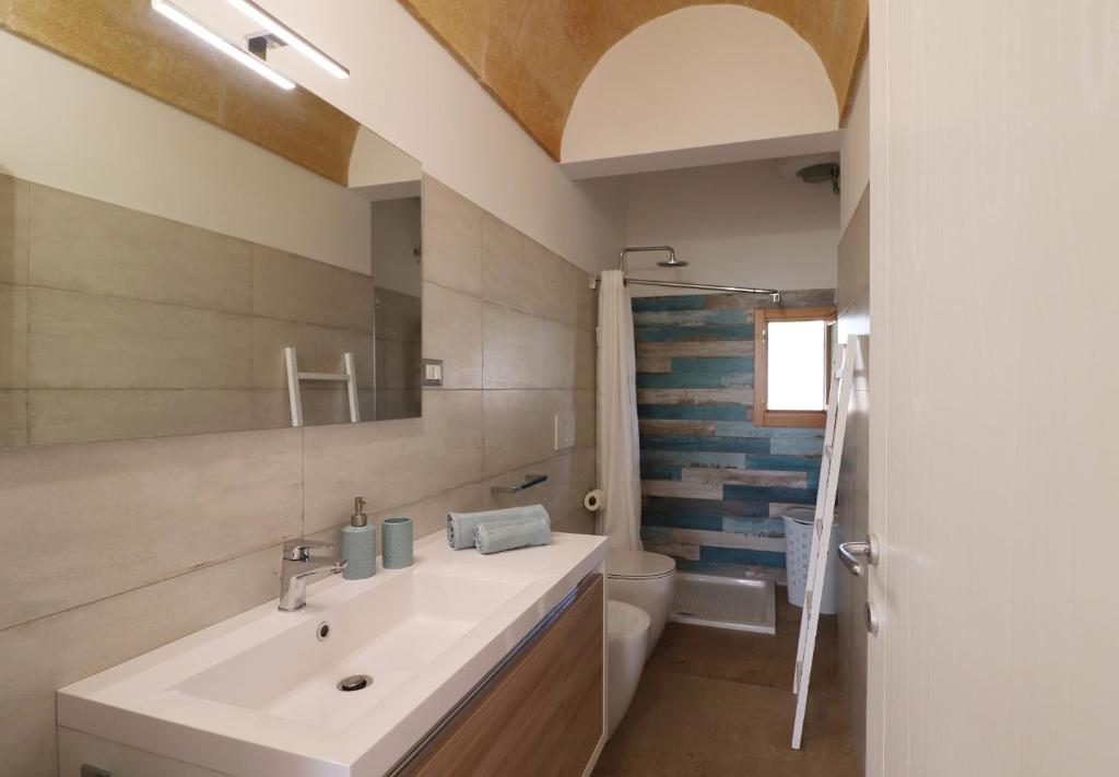 une salle de bain avec un lavabo et des toilettes dans l'établissement Villetta Marechiaro, à Marina di Pescoluse