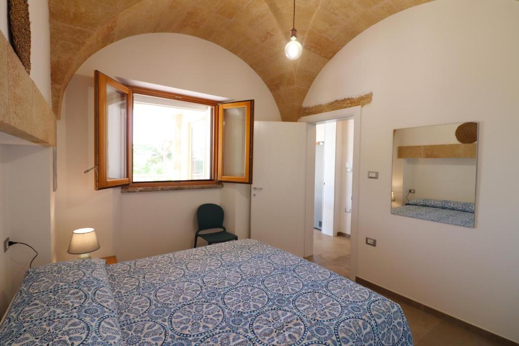 une chambre avec un lit, une fenêtre et un miroir dans l'établissement Villetta Marechiaro, à Marina di Pescoluse