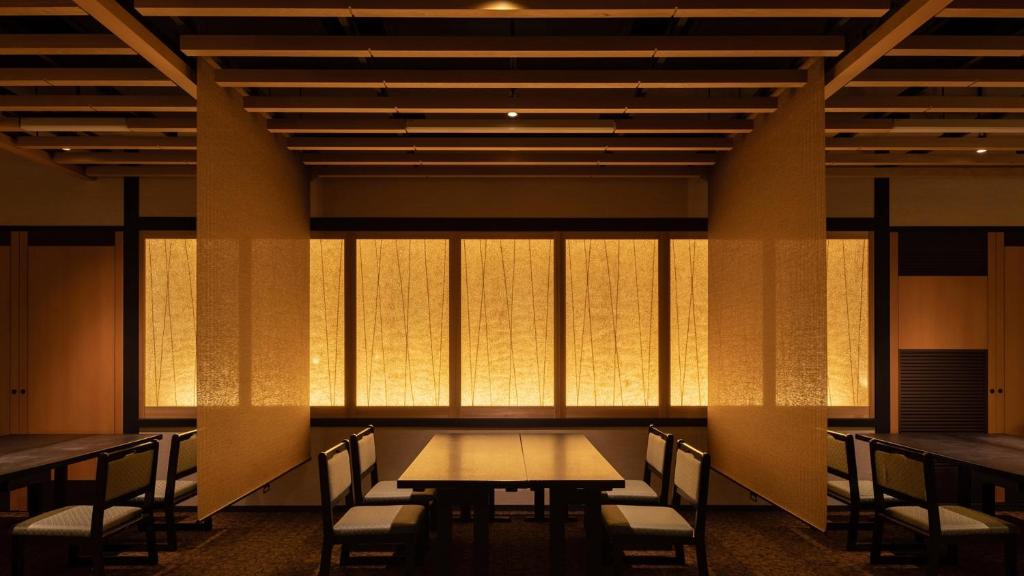 une salle à manger avec tables, chaises et fenêtres dans l'établissement Hotel Kurobe, à Kurobe 37 autres photos