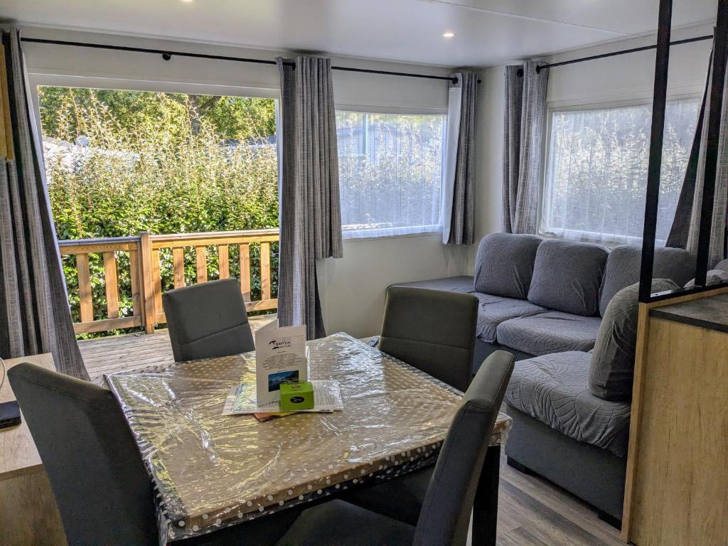 un salon avec une table et un canapé dans l'établissement Mobil Home 205 6 à 8 personnes, à Gastes