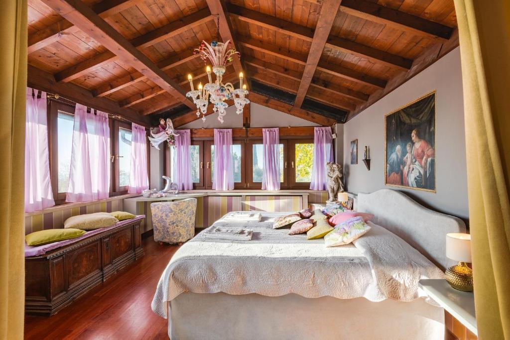 une chambre avec un grand lit et un lustre dans l'établissement Villa Isidoro ampio parco ,piscina privata, arte e giochi , fitness, à Vérone