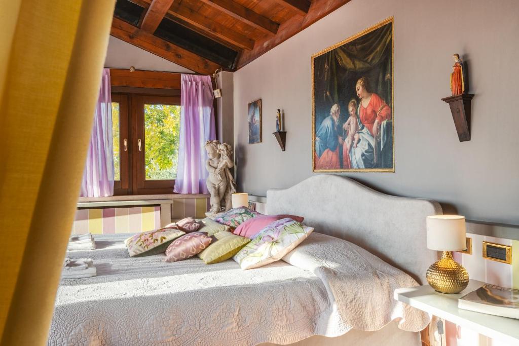 une chambre avec un lit et un tableau au mur dans l'établissement Villa Isidoro ampio parco ,piscina privata, arte e giochi , fitness, à Vérone 132 autres photos