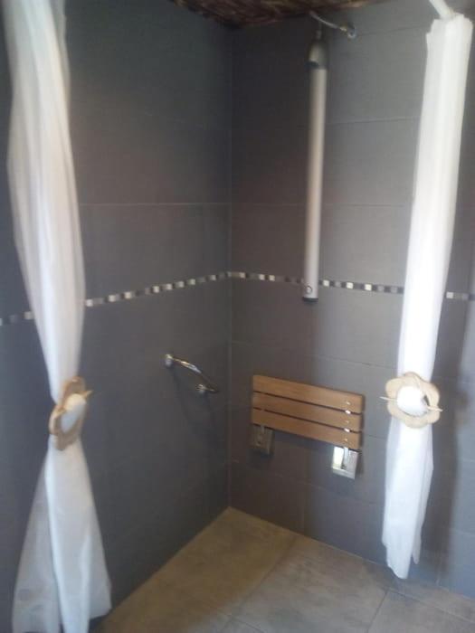 - une salle de bains avec un banc et 2 rouleaux de papier toilette dans l'établissement Cabane en bois POD 1, à Champfromier
