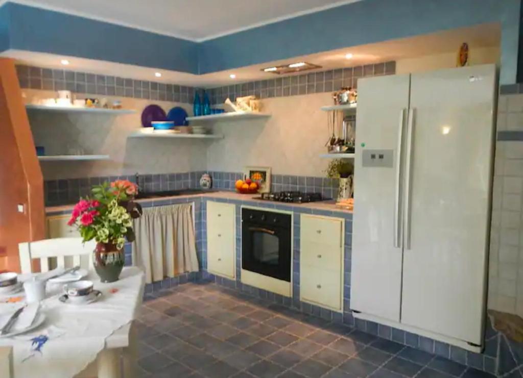 une cuisine avec un réfrigérateur blanc et une table dans l'établissement Villa Migi, à Archi