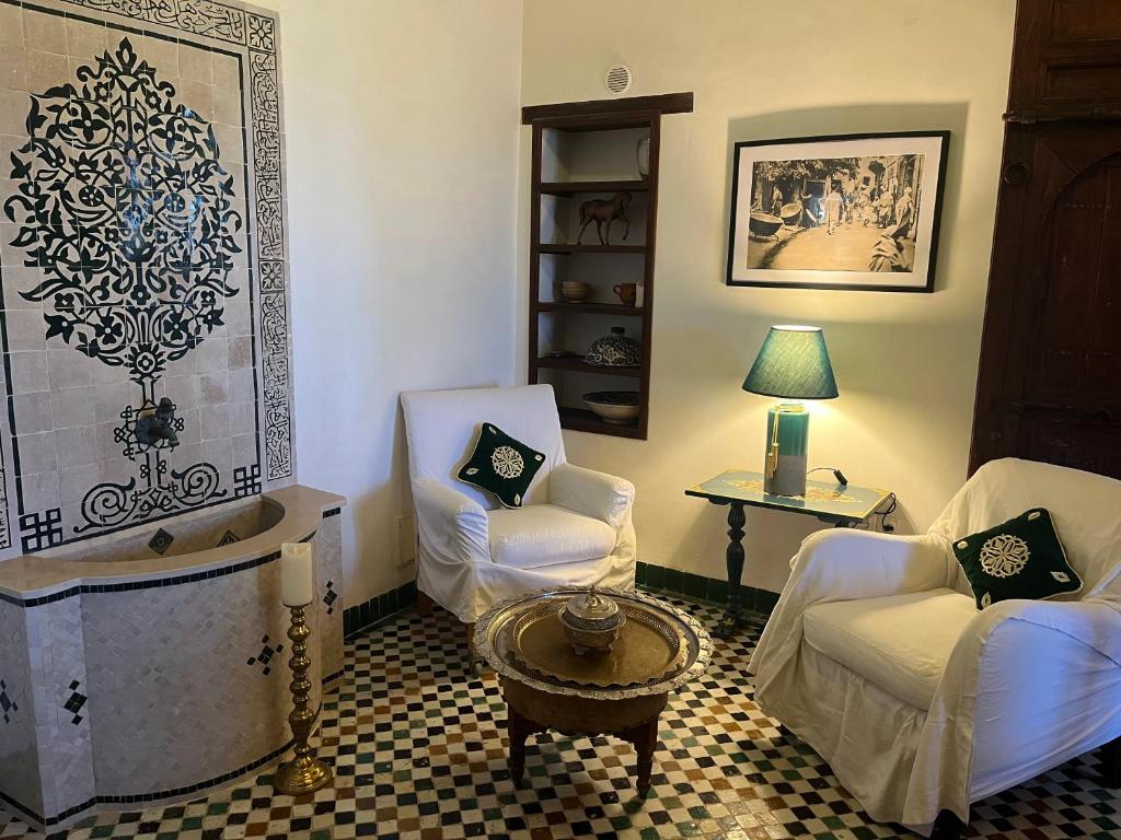 un salon avec deux chaises et une table dans l'établissement Riad Hanael Garden & Spa, à Fès