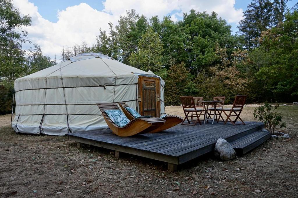 une yourte avec des chaises, une table et des chaises dans l'établissement Yourte mongole, à Champfromier 10 autres photos