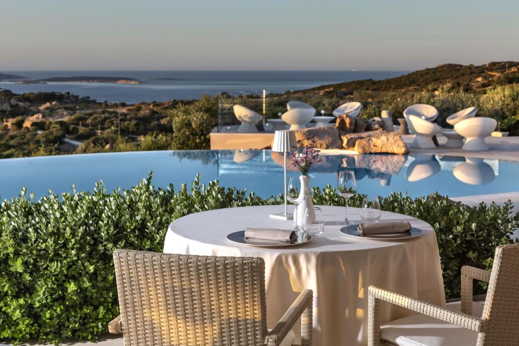 une table et des chaises avec vue sur l'océan dans l'établissement Hotel Li Finistreddi, à Cannigione