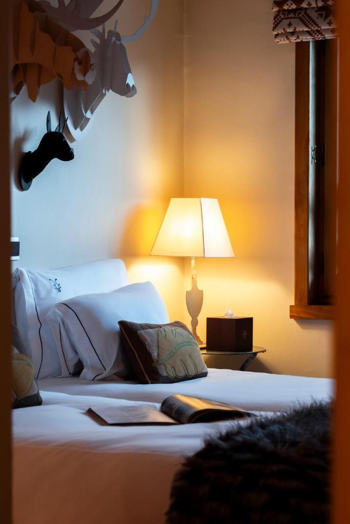 - une chambre avec un lit et une lampe dans l'établissement Alpes Hôtel du Pralong, à Courchevel