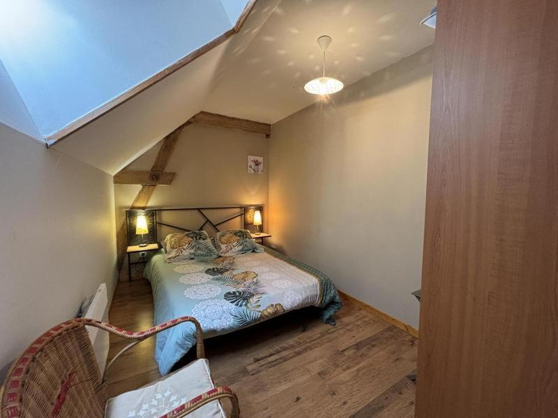 une chambre avec un lit dans le coin d'une pièce dans l'établissement Gite de la roseraie, à Louchy-Montfand