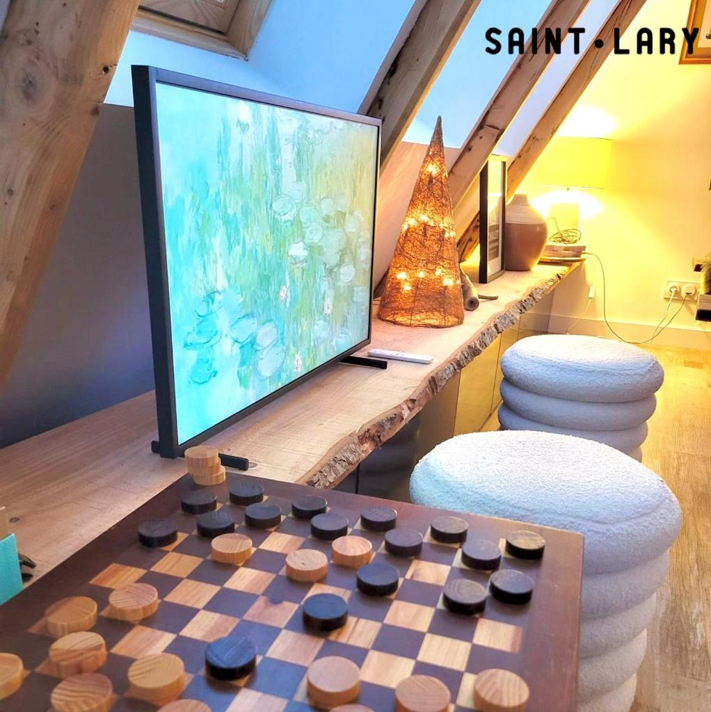 - un salon avec une télévision et un échiquier dans l'établissement Chalet 6-9 pers St Lary Alt1700m -100mdespistes classé 4 étoiles, à Saint-Lary-Soulan