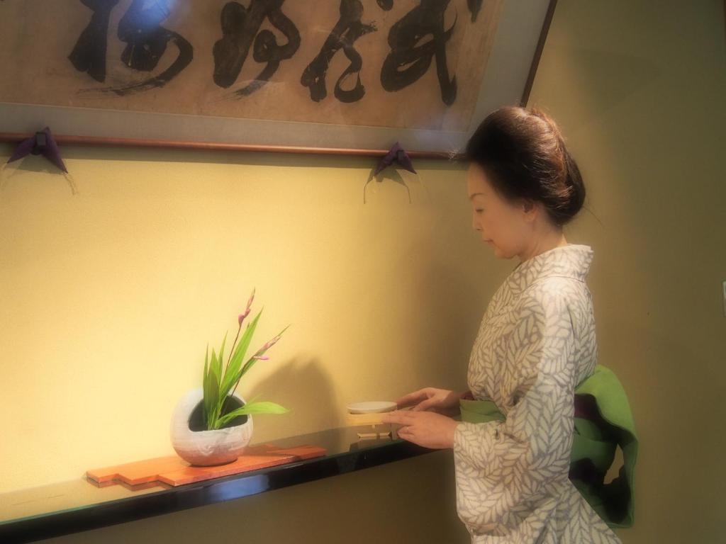 une femme debout à côté d'une table avec une plante dans l'établissement Kotonoyado Musashino, à Nara 37 autres photos